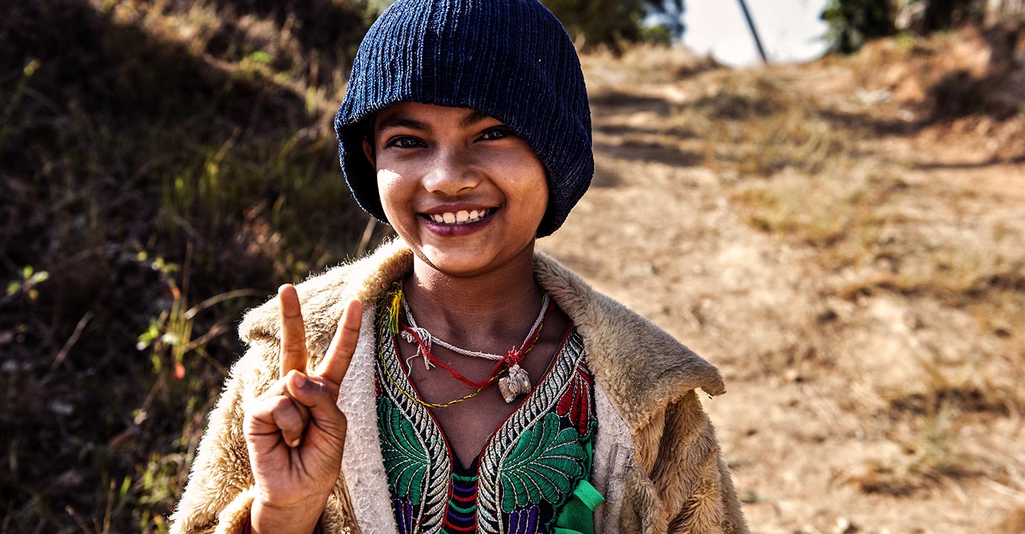 Girl in Nepal holding up the peace sign 