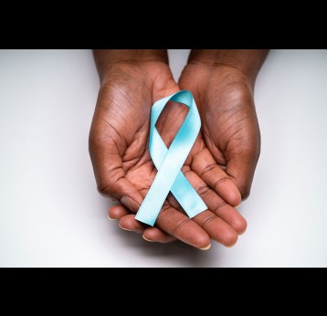 Human hands holding teal ribbon to support cervical cancer awareness