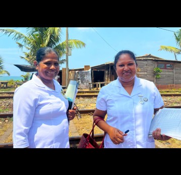 Samanthi Priyangika Dias et la sage-femme H. P. Nadeera s’arrêtent près de la voie de chemin de fer à la fin de leur travail sur le terrain. La communauté de la pêche a grandement besoin de leurs services. Crédit : Aanya Wipulasena