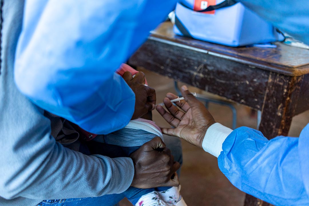  A health worker administers the typhoid vaccine injection to a child