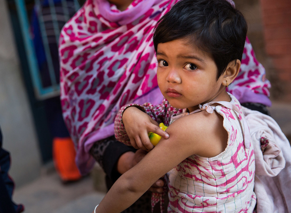A girl looks at the camera after receiving a vaccination