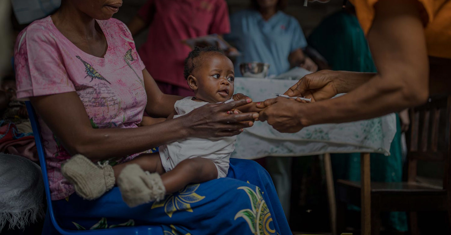 Baby getting a vaccine in mom's lap 