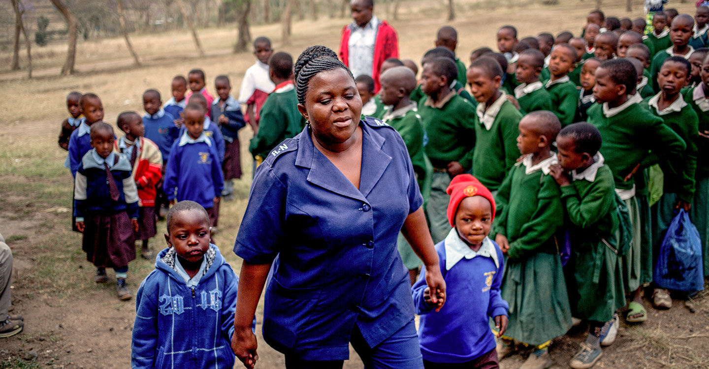 Nurse in Tanzania walking with two small boys