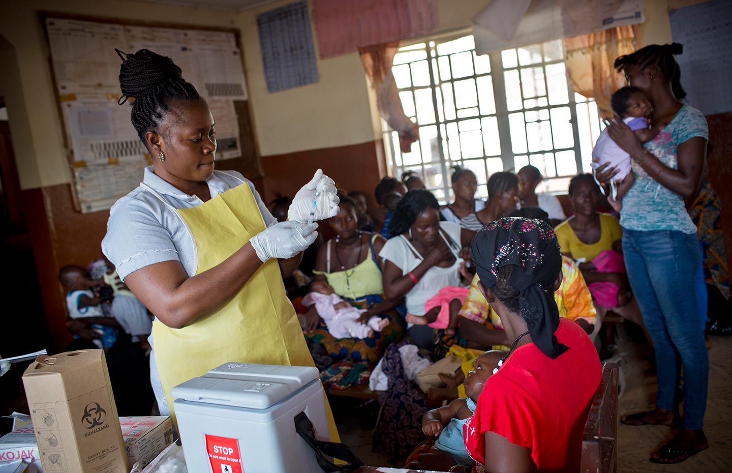 A health worker prepares to vaccinate a baby with a routine vaccination at a health clinic in Freetown. Credit: Gavi/2016/Kate Holt.