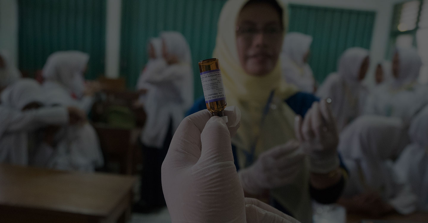 Vaccine vial and health worker in the background