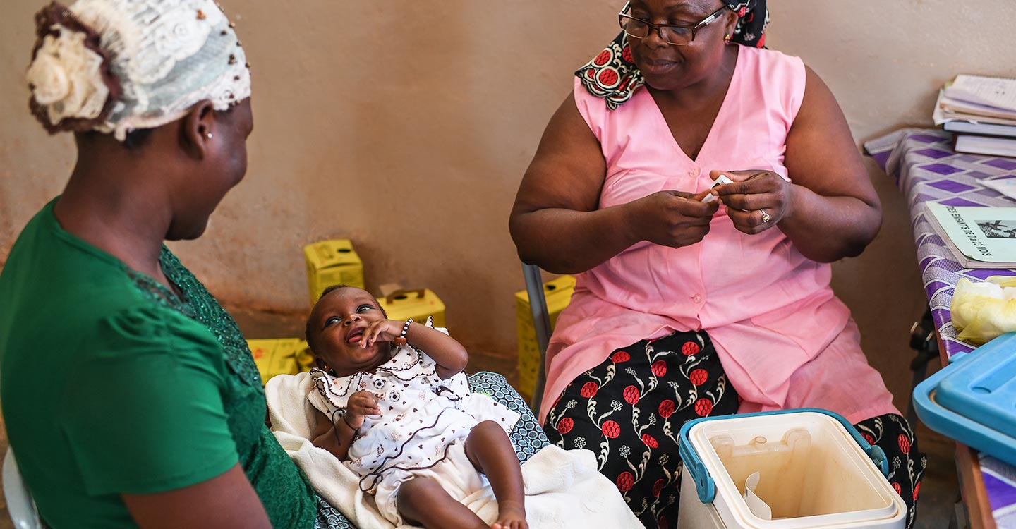 Female health worker, mother and child. Credit: Gavi/Tony Noel.
