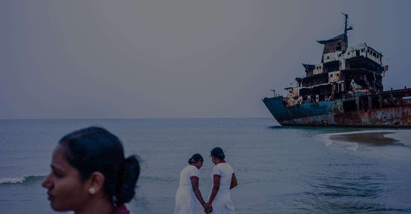 two nurses holding hands on water edge