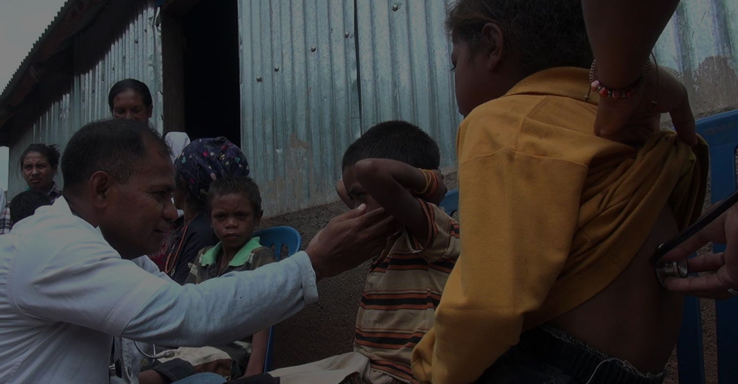 doctor inspecting a child in tl village