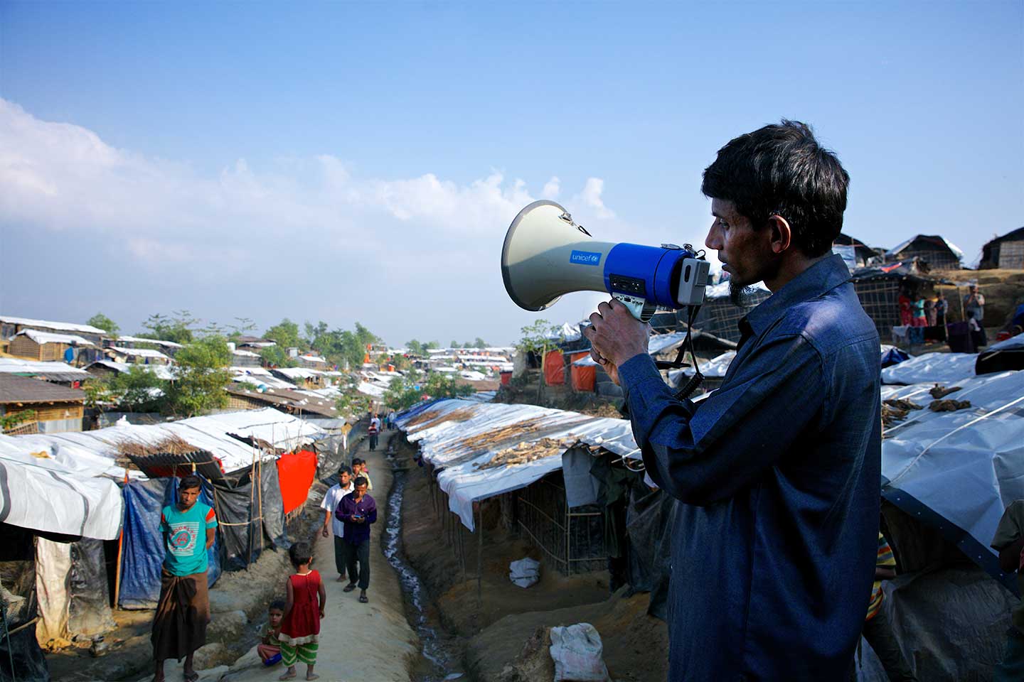 A volunteer provides health information to Rohingya refugees outside a UNICEF-supported vaccination centre at Bormapara, Cox's Bazar, Bangladesh. Credit: UNICEF/b.a.sujaN/Map.