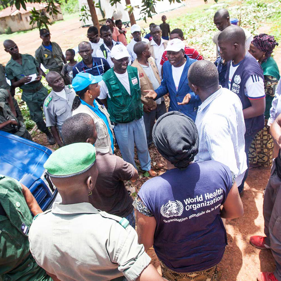 Coordinator of Guinean Ebola Response team speaks to people manning a road block. The blocks help to educate people and identify anyone infected, allowing them to be treated and the transmission of disease reduced. "Ring vaccination" was used in the 1970s to eliminate smallpox.