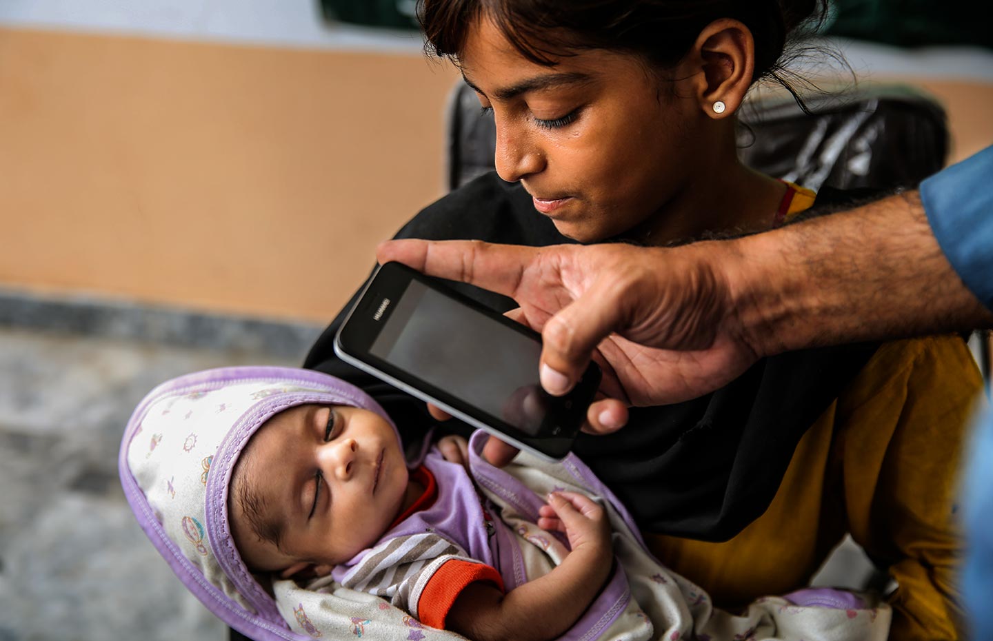  GAVI/2017/Asad Zaidi/An EPI worker, Mohammad Saim, entering Adeel’s (15 days old) data into the EVACC mobile app during an urban slum field visit in Bund Road Lahore, Punjab province