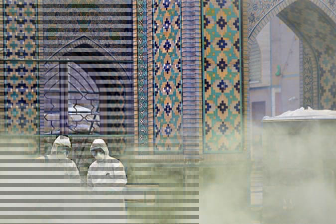 Image from Aljazeera article – Members of a medical team spray disinfectant to sanitise an outdoor area at Imam Reza's Holy Shrine in Mashhad [WANA via Reuters]