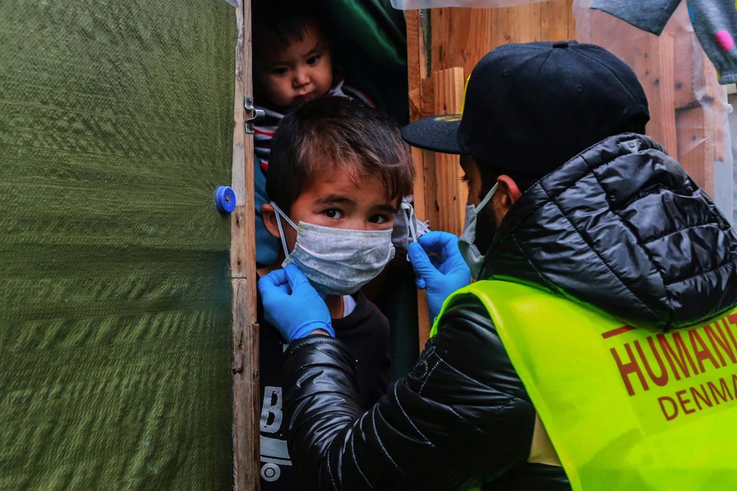 A member of NGO "Team Humanity" shares handmade protective face masks to migrants and refugees in the camp of Moria in the island of Lesbos CREDIT: AFP A member of NGO "Team Humanity" shares handmade protective face masks to migrants and refugees in the camp of Moria in the island of Lesbos CREDIT: AFP