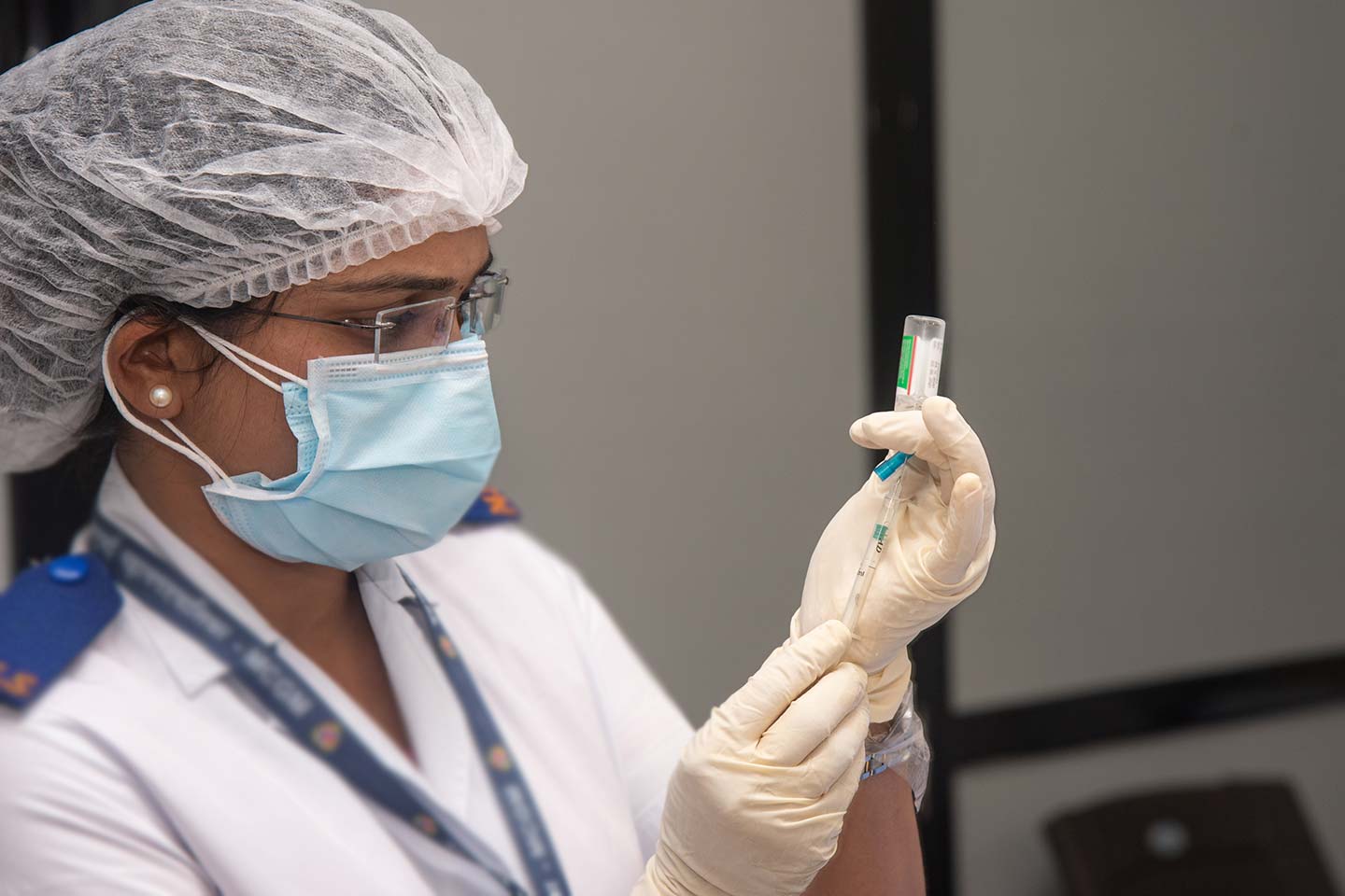 A medical worker prepares vaccine for front line workers at the Shatabdi Hospital