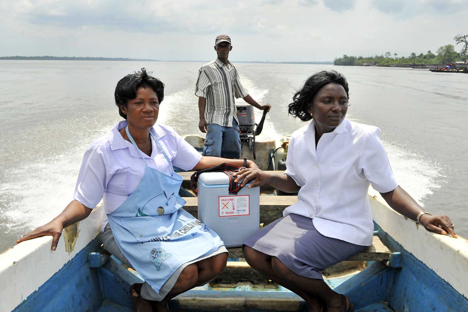 Universe Enebong (à gauche) et Angelica Ujaga, agents de santé communautaires, traversent l’embouchure de l’Atlantique dans l’État de Cross River pour gagner les villages reculés accessibles uniquement par bateau.