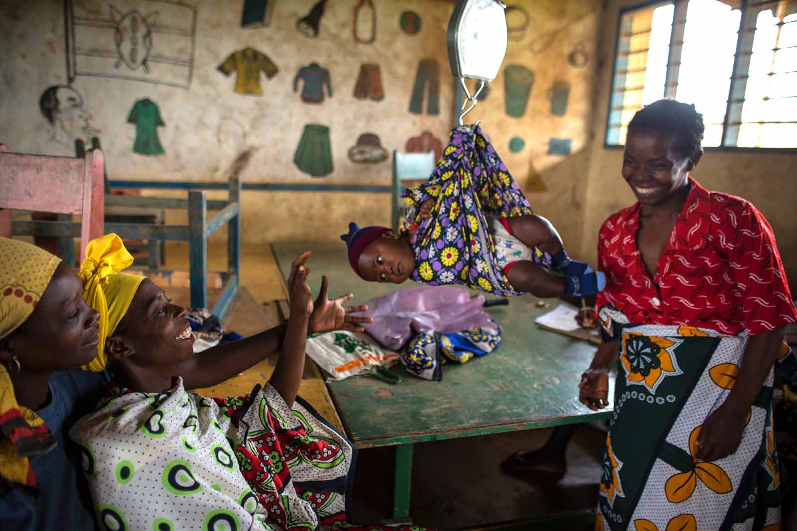  Mothers weigh their babies before they are vaccinated at the outreach health clinic set up in the tin-roofed classrooms at Ngamani Primary School.