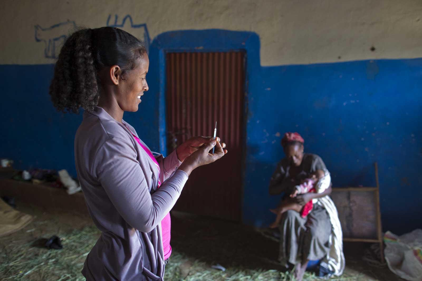 As in Afar, home visits are critical to reaching more children, and health extension workers like Shewangezhew Moges walk kilometres daily to visit rural families. Here she prepares a vaccine for Frehiwot Alemayehu, six months old. The baby’s mother Kuli Aredo had missed an appointment at the health centre 13 days ago.
