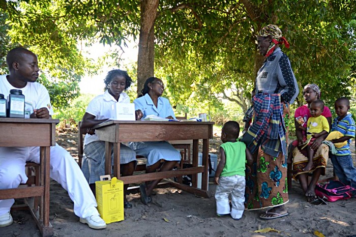 Health workers, seated at chairs and tables borrowed from the school, attend a flow of patients. Most are mothers and babies waiting for immunisation but today 82-year-old village elder Albertina Macic gets a dose of paracetamol from nurse Lidia Domingos Cossa to soothe a flu attack.