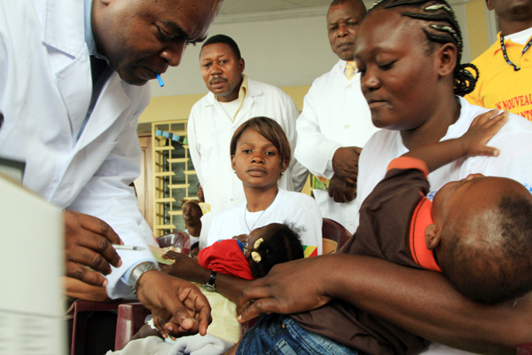 Près de 200 mères congolaises regardent un enfant recevoir la toute première dose de vaccin anti-pneumococcique. 
