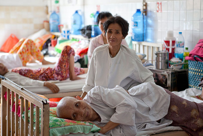 Patients sit or lie on their beds at the Ho Chi Minh City Oncology Hospital in Vietnam, December 2010.
