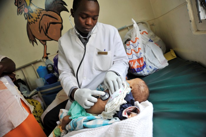 Boniface Ajwala, medical officer at Langata, listens to the breathing of Esther Wabui, aged five. Esther is undergoing treatment for pneumonia. Nearly half of the children treated at the health centre are brought in suffering from pneumonia.
