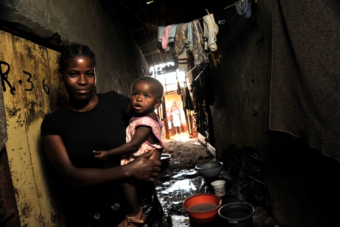 Josephine Anyango, aged 21, stands outside her house in Kibera with her 11-month-old daughter Michelle Atieno. Aware of the risks of contracting pneumonia, Juliet was one of the mothers queueing to vaccinate their children at the ICC launch event.