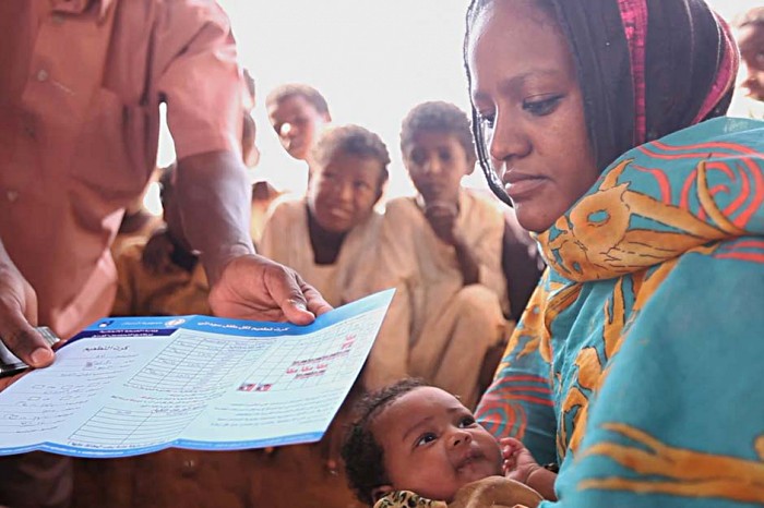 At Baruka Village, Raja Ali Khider watches as health officials register her two-month-old daughter Zuhir Noran’s rotavirus vaccination. Each vaccine delivered is recorded on immunisation cards to facilitate monitoring.  