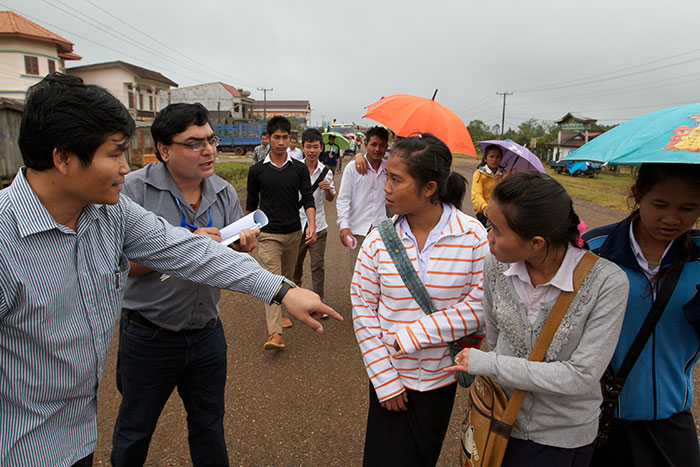 Dr. Phounphenjhack Kongxay, Lao's Deputy Manager of the national immunization programme and WHO's Rajesh Bhaskar check students’ fingers as they head home from school in Paksong District high on the Bolaven Plateau in November 2011.  Young people are marked with purple ink on their left pinky fingers following immunisation so that monitors can quickly tell if they have been reached by the campaign.