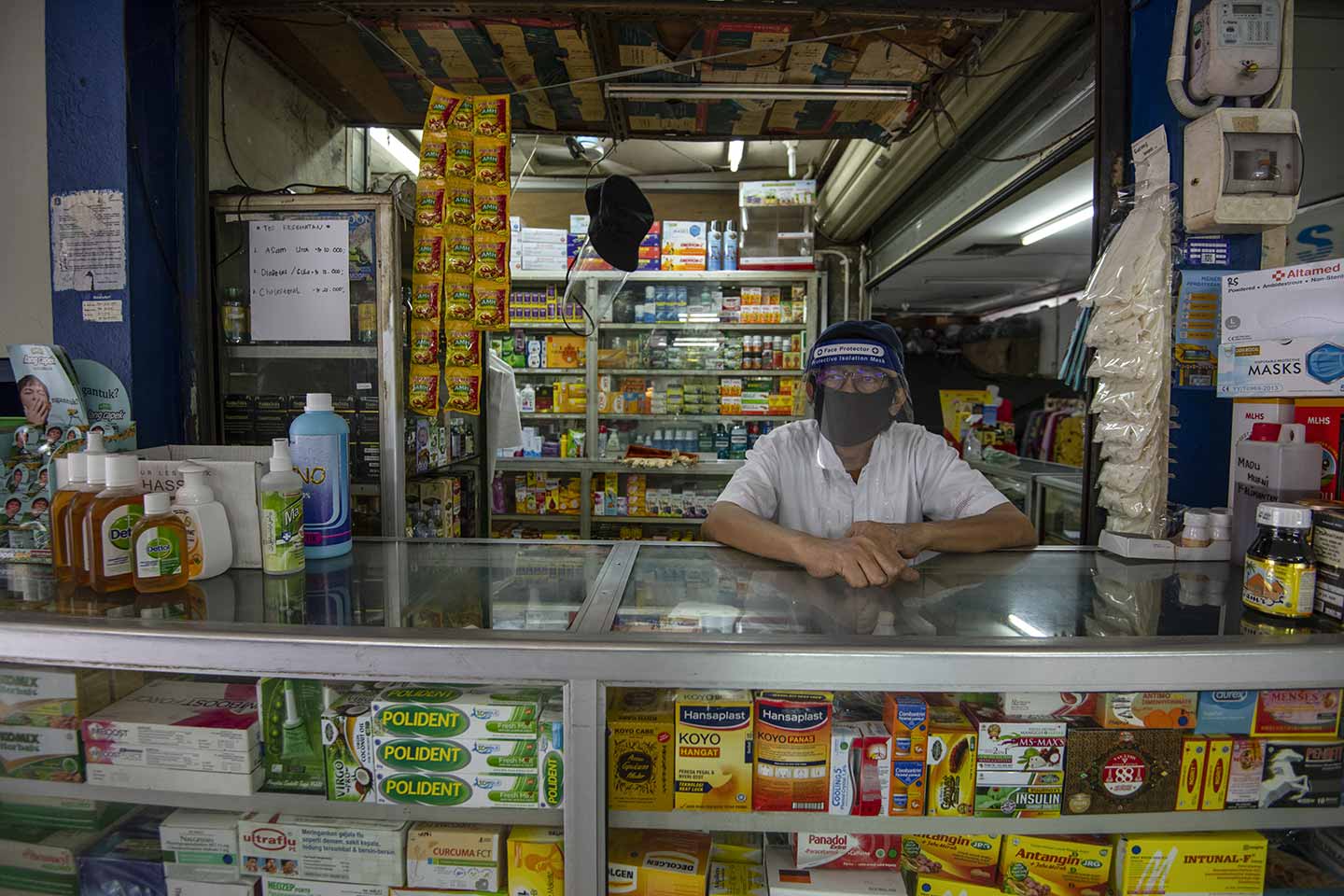 Drugstore owners serve shoppers by wearing masks and face protector during the Covid-19 outbreak in South Jakarta, Indonesia on April, 2020.  Credit: UNICEF/2020/Arimacs Wilander