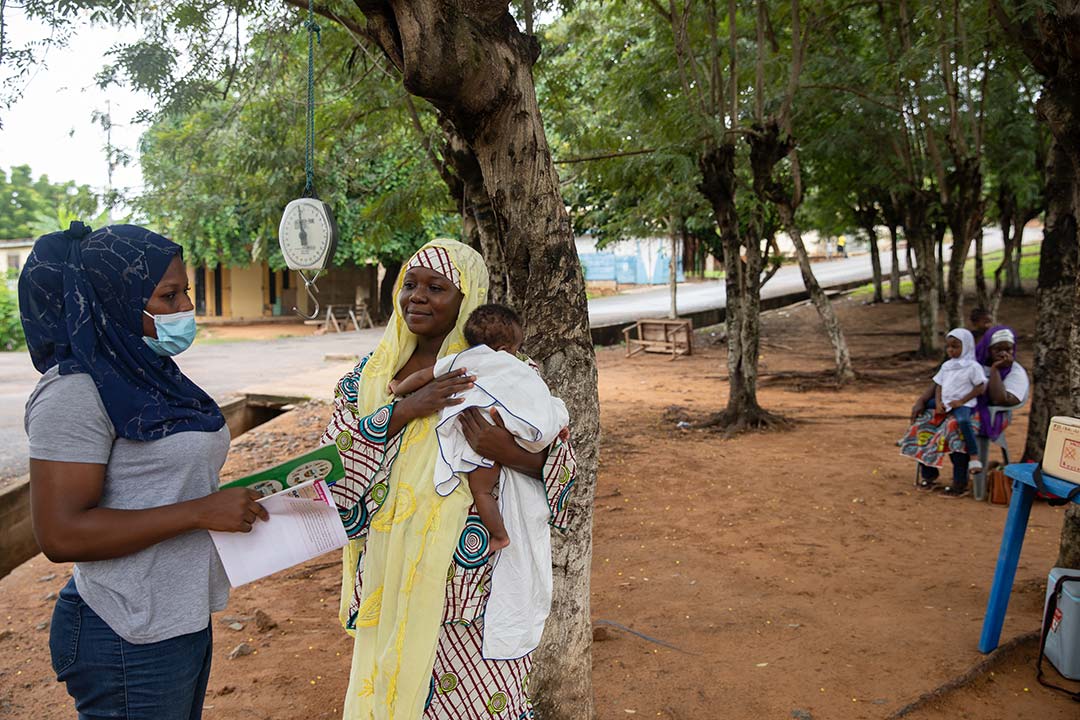 A health worker interacts with a mother during a community health check-up and vaccination. Gavi/2022/Nipah Dennis