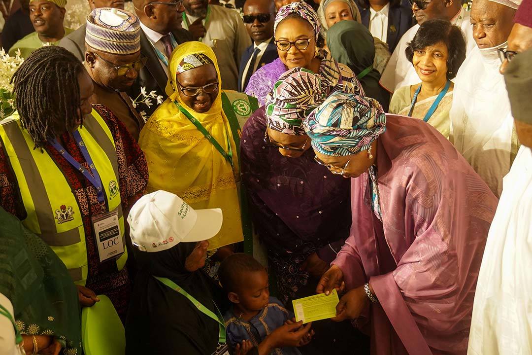 The First Lady of Nigeria is Senator Oluremi Tinubu holds up a vaccine card after administering a dose to a child during the national flag-off of the integrated health campaign at the Banquet Hall, State House, Abuja.