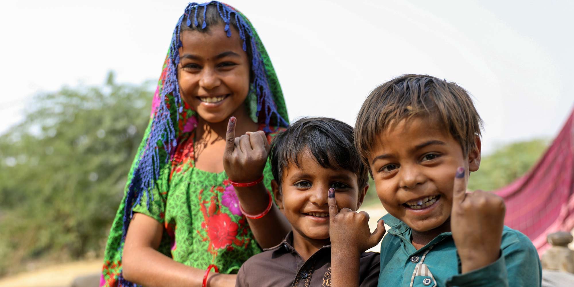 Children show the ink mark on the tip of their finger, evidence of vaccination against measles and rubella during the nationwide campaign in Tharparkar District, Pakistan. Credit: Gavi/2021/Asad Zaidi.