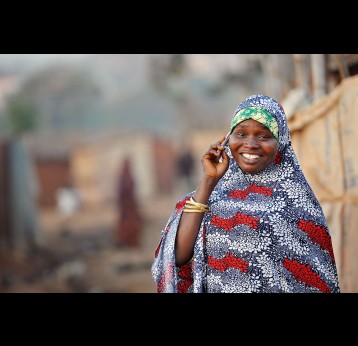 A woman on a mobile phone in Nigeria. Credit: Gavi/2013/Adrian Brooks.