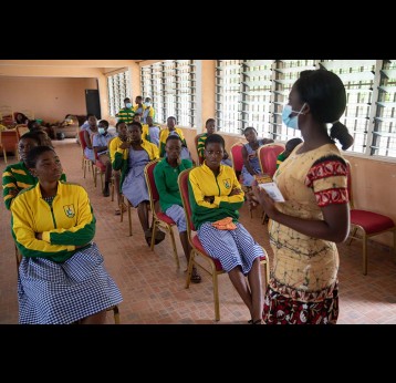 A health worker interacts with students on the COVID-19 vaccine in Adukrom in the Eastern Region, Ghana, on April 27, 2022. Ghana pushes towards community vaccination to increase its vaccinated population. Gavi/2022/Nipah Dennis