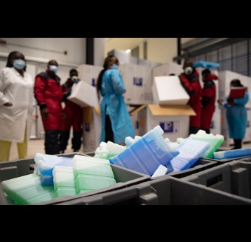 Cold chain staff unpack the COVID-19 vaccines for storage in the cold room. Vaccine storage warehouse, Kinkole commune, Kinshasa, DRC. – Credit: Desjardins Sibylle