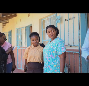Mirriam Sikaputa, une infirmière diplômée de 26 ans, vaccine les filles de l'école David Hamushu à Kabwe. Avec Miriam, la jeune championne Mirriam Botha, 13 ans, sourit après avoir reçu son vaccin contre le VPH. UNICEF/2023/Mapalo Mwenya