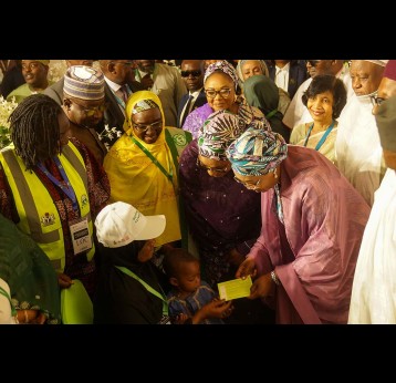 The First Lady of Nigeria is Senator Oluremi Tinubu holds up a vaccine card after administering a dose to a child during the national flag-off of the integrated health campaign at the Banquet Hall, State House, Abuja.