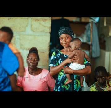 A mother stands with her newborn during the nationwide malaria vaccine campaign at a health centre in Sierra Leone. Credit: Gavi/2024/Dominique Fofanah