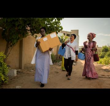 Gavi/2018/Simon Davis- Health workers from the Dakar North District immunisation "outreach" team set out on foot after reaching the end of the built road. They are taking vaccines to families in Nabisouikr, one of Dakar's slum areas