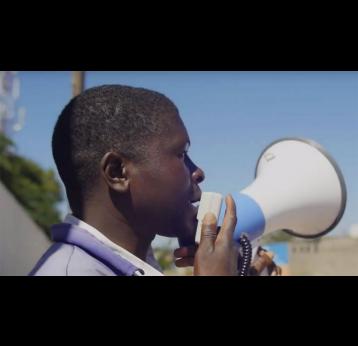 Health worker announcing vaccination session through a megaphone