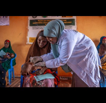 Nurse administers an oral vaccine to a child, held by his grandmother in Southwest State, Somalia. Credit: Mohamed ​Abdihakim ​Ali 