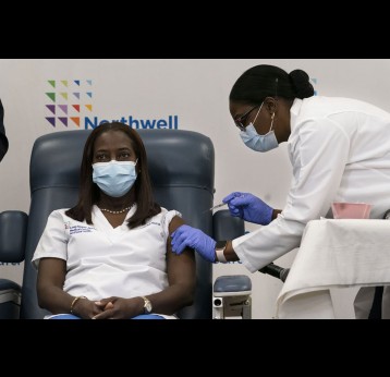 Sandra Lindsay, a nurse at Long Island Jewish Medical Center, is given the COVID-19 vaccine – she is one of the first in the US to receive it. EPA/Mark Lennihan