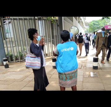 A Community health worker, Ms Elizabeth Oduor uses a loudspeaker to mobilise people to get COVID-19 jab at Nairobi's Kencom bus stage. Credit: Mike Mwaniki.