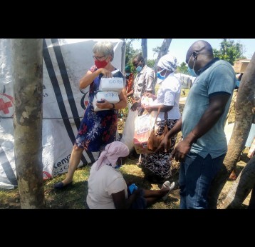 Safe Water and Aids Project (SWAP) founder Ali Eleveld (in a red mask ) distributes Covid-19 safety kits to Ombaka  flood victims on June 8,2021 .Apart from supplying the victims with safety kits,the Non-government Organization through partnership with the Ministry of Health works on ensuring the vaccine is easily accessible to the victims in the camp .Photo Credit/Angeline Ochieng