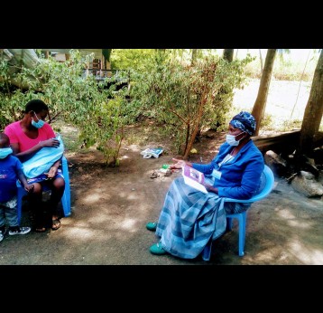 Ms Frandiscah Amolo educates Ms Emily Atieno on the importance of early childhood vaccinations and COVID-19 safety measures at her home in Holo, Kisumu County in Kenya on July 2, 2021. Photo credits /Angeline Ochieng 