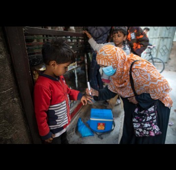 A health worker after administering polio drops to a child putting identification mark on his little finger during nationwide door to door campaign in (urban) high risk union council 8 in Fauji Colony, Rawalpindi, Pakistan. which is a predominantly Pashtoon community – Credit: Asad Zaidi