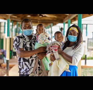 Parents hold their children at the Malava County Hospital, Kakamega, Kenya. – Gavi/2021/White Rhino Films-Lameck Orina