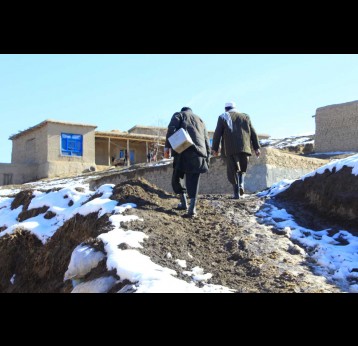 Volunteers Abdul Basit and Misbahuddin trek up a hill in Aab-e-barik village, Argo district, Badakhshan province. ©Shaim Shahin/WHO Afghanistan