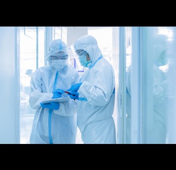 Two asian woman doctor in personal protective suit or PPE with mask writing on quarantine patient chart, holding test tube with blood sample for screening coronavirus.