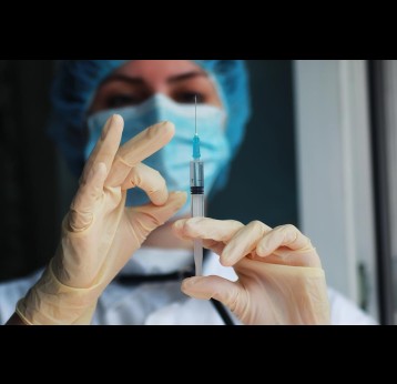 Nurse hands holding syringe and ampoule